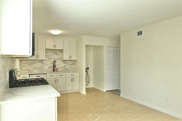 a kitchen with white cabinets and stainless steel appliances
