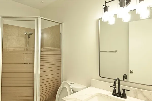 an empty room with a chandelier fan and wooden floor