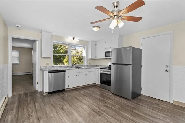 a kitchen with granite countertop white cabinets and white appliances