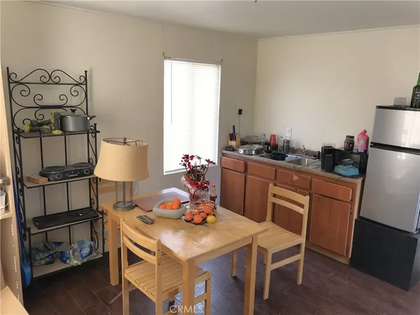 a kitchen with a refrigerator and table chairs