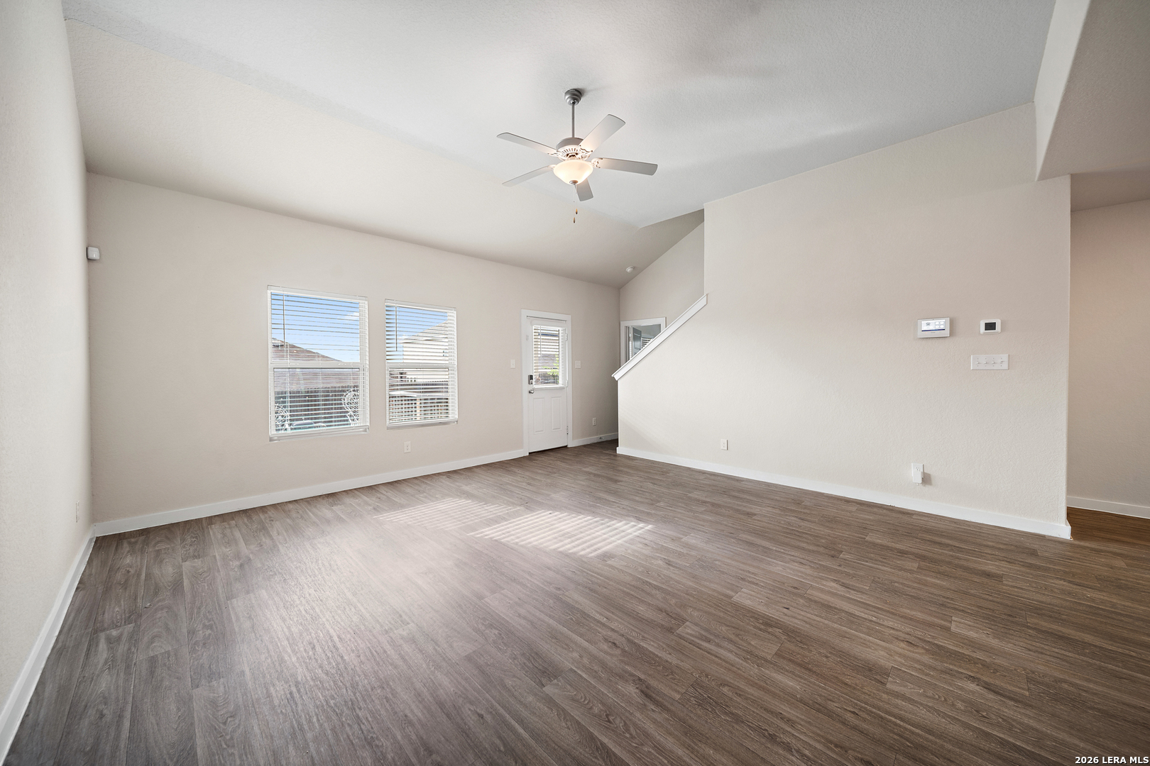 6914 Cetera Way Converse, TX 78109 - Photo 13 of 32 an empty room with wooden floor chandelier fan and windows