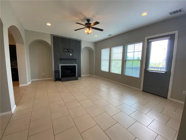 a view of an empty room with a fireplace and a window