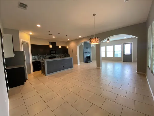 a open kitchen with stainless steel appliances kitchen island granite countertop a refrigerator and a sink