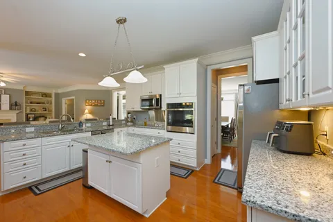 a kitchen with granite countertop a sink counter top space appliances and cabinets