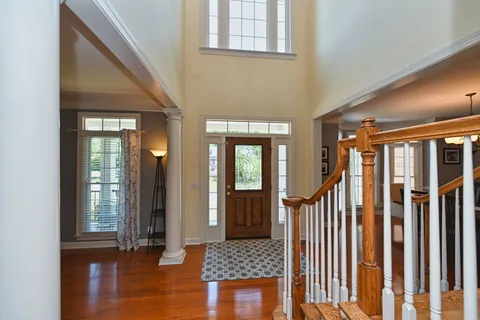 a view of a hallway with wooden floor and stairs
