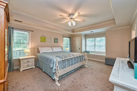 a bedroom with a bed chandelier and a window