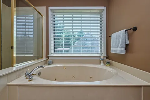 a white bath tub sitting in a bathroom next to a window