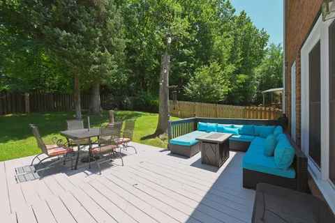 a view of deck with furniture and garden