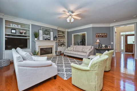 a living room with furniture a flat screen tv and a fireplace