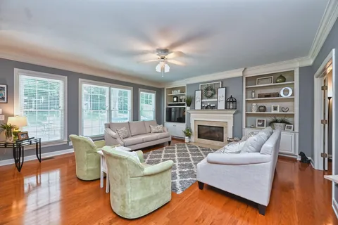 a living room with furniture a fireplace and a floor to ceiling window
