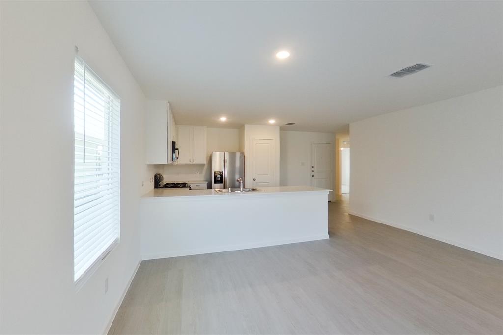 807 Ginkgo Way Princeton, TX 75407 - Photo 11 of 22 a view of kitchen and kitchen with furniture wooden floor and window