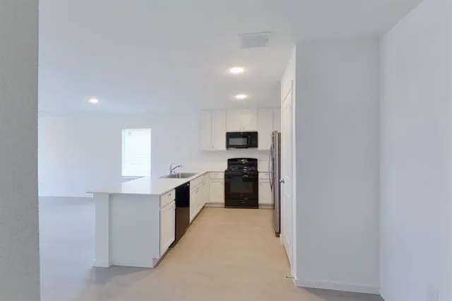 a kitchen with white cabinets and a sink