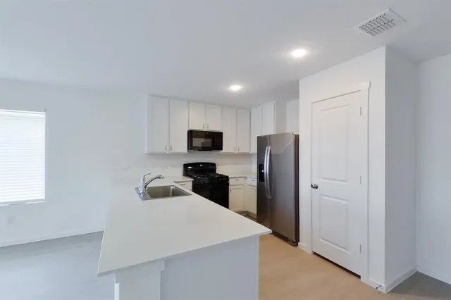 a kitchen with stainless steel appliances a refrigerator sink and microwave