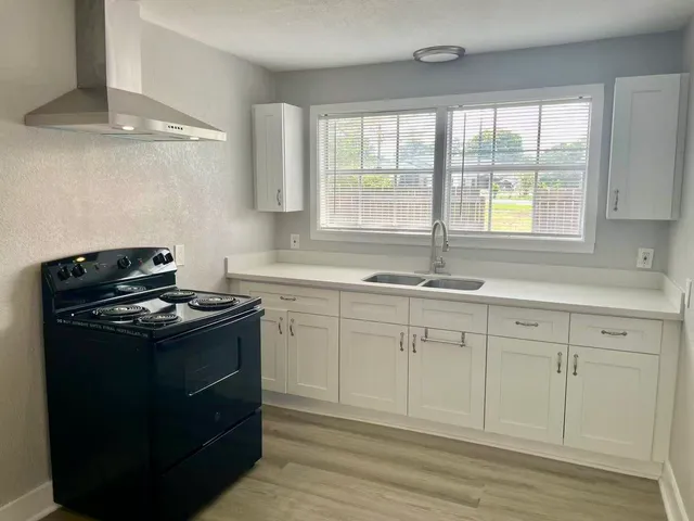 a kitchen with granite countertop a stove and a sink