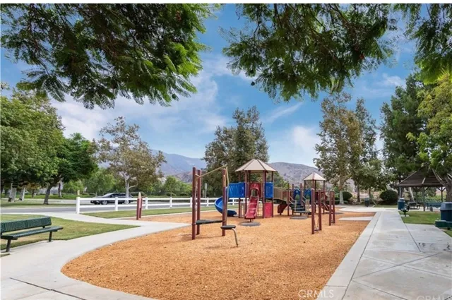 a swimming pool with outdoor seating and trees in the background