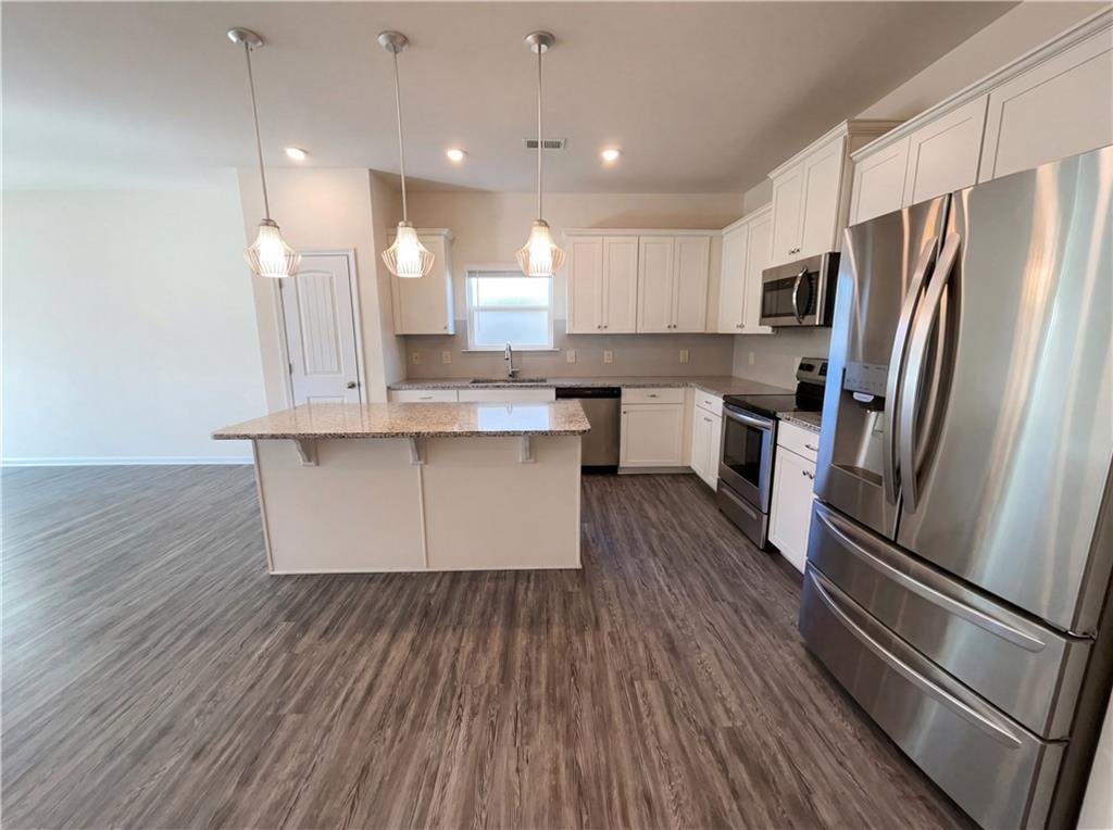 2682 North Broad Street Extension Northeast Rome, GA 30161 - Photo 8 of 23 a kitchen with kitchen island wooden floors white appliances and cabinets