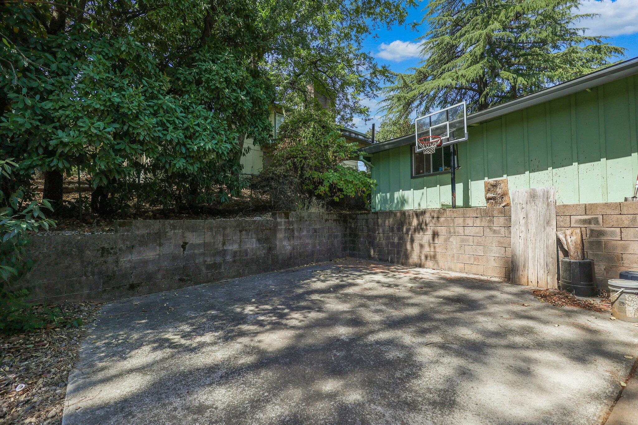 665 Overhill Drive Redding, CA 96001 - Photo 33 of 35 a backyard of a house with lots of green space and fountain