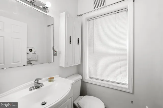 an empty room with wooden floor ceiling fan and windows