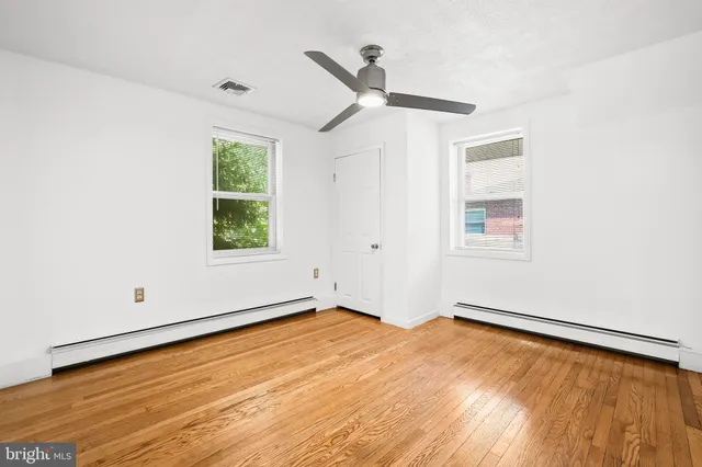 a view of empty room with wooden floor