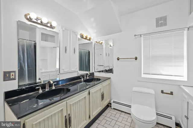 a bathroom with a sink a toilet a mirror and shower