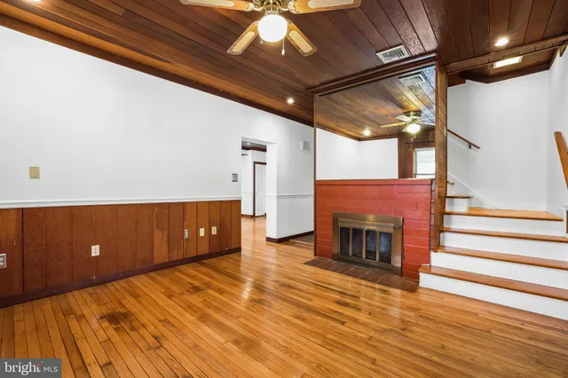 a kitchen with stainless steel appliances granite countertop a refrigerator a sink a stove and white cabinets with wooden floor