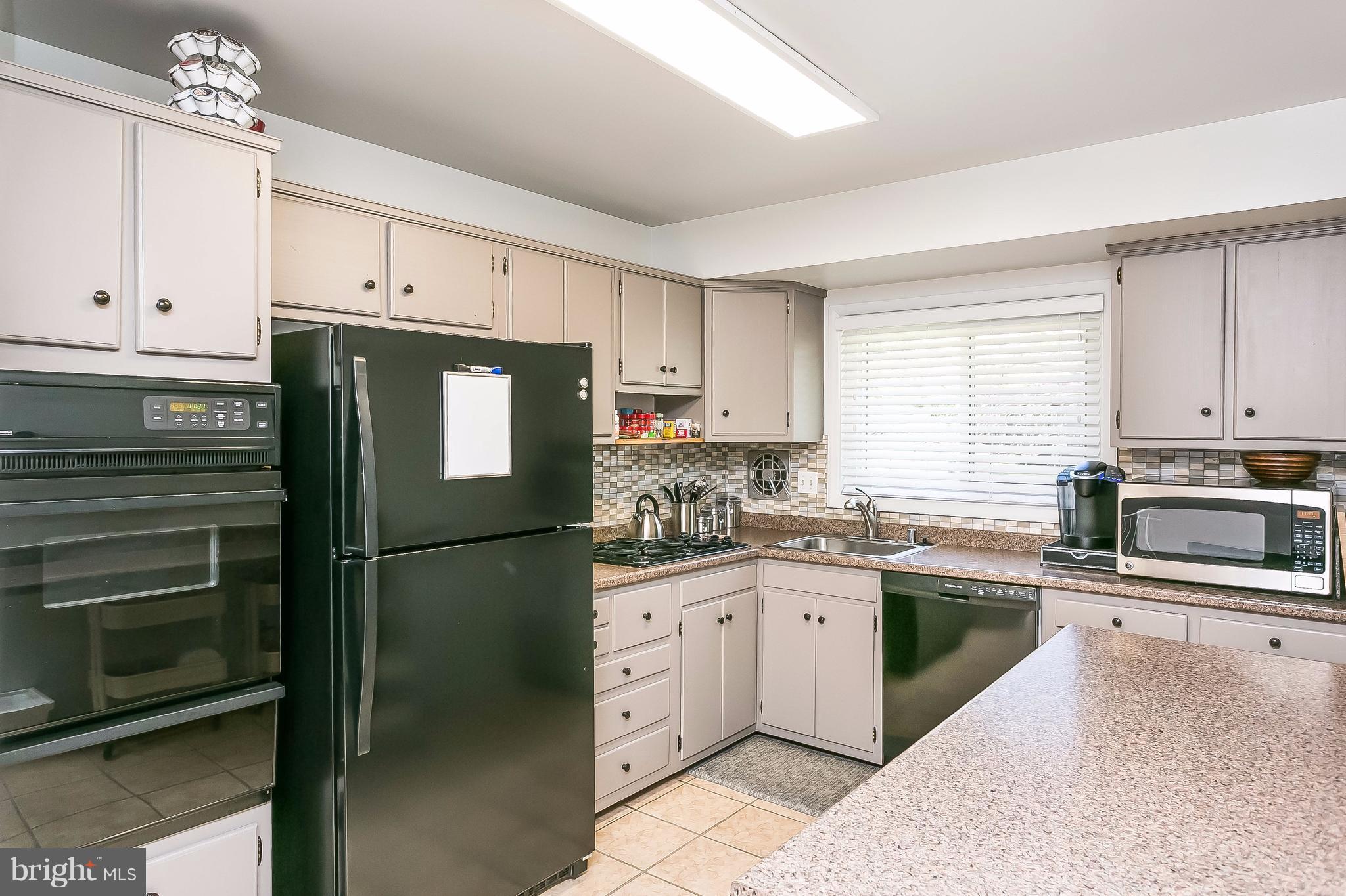 7313 Campfield Road Baltimore, MD 21208 - Photo 6 of 19 a kitchen with stainless steel appliances a refrigerator sink and cabinets