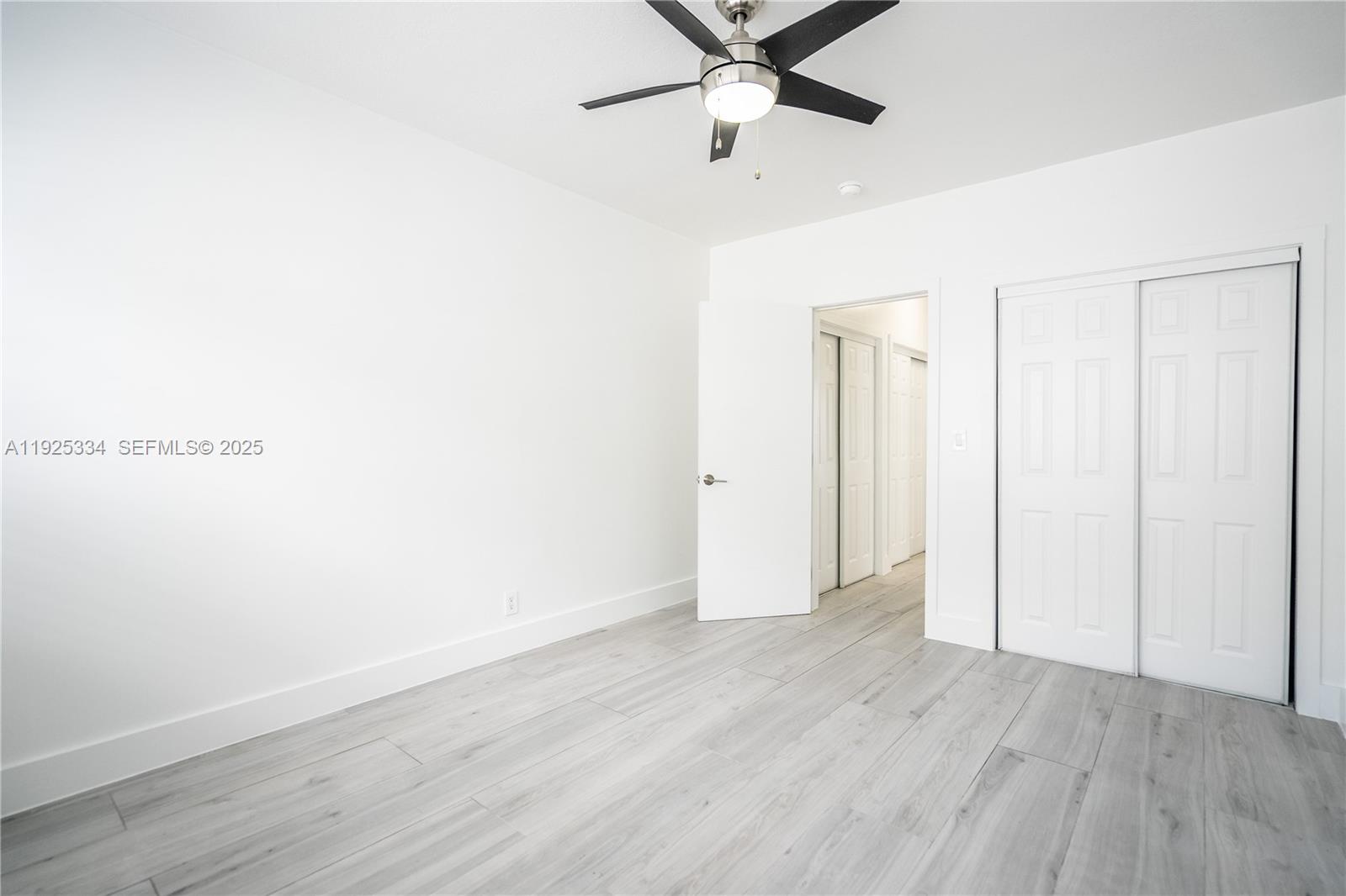 330 84th Street, Unit 9 Miami Beach, FL 33141 - Photo 11 of 16 an empty room with wooden floor closet and fan