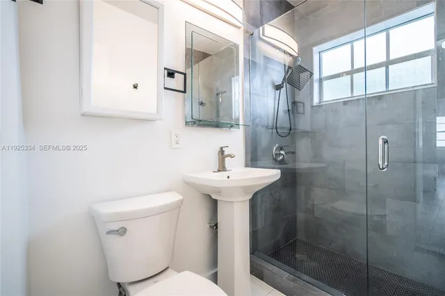 a bathroom with a sink toilet and shower