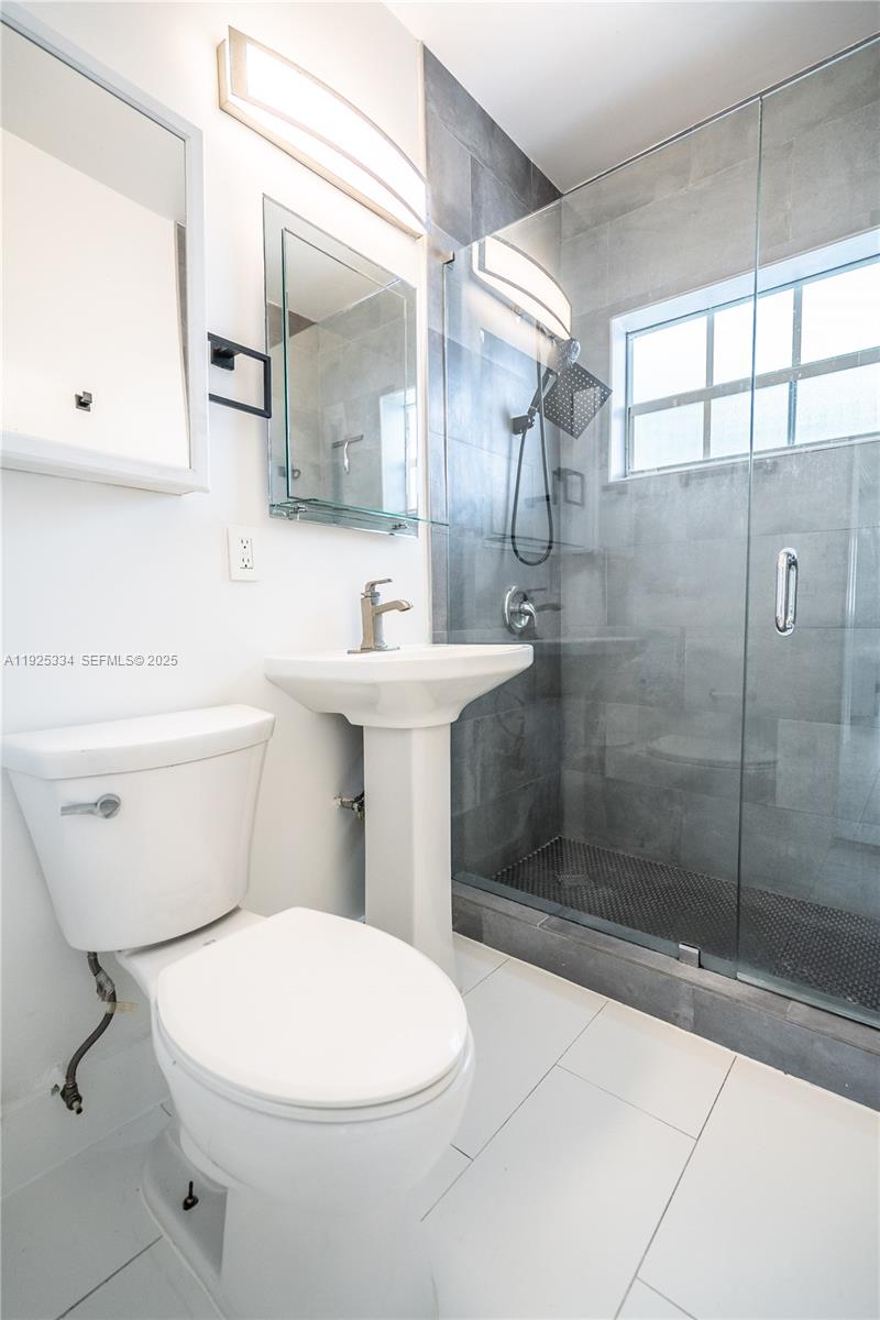 330 84th Street, Unit 9 Miami Beach, FL 33141 - Photo 14 of 16 a bathroom with a toilet sink and shower
