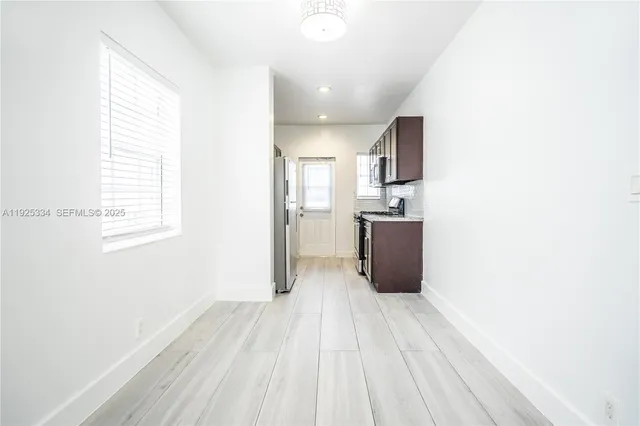 a room with a window and refrigerator