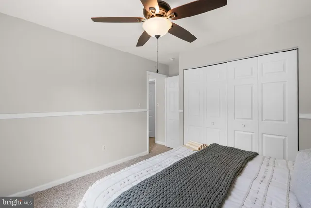 a bedroom with a bed and a ceiling fan