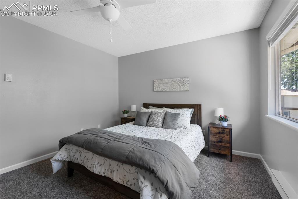 757 Alexander Road, Unit C Colorado Springs, CO 80909 - Photo 16 of 29 Carpeted bedroom featuring ceiling fan and a textured ceiling
