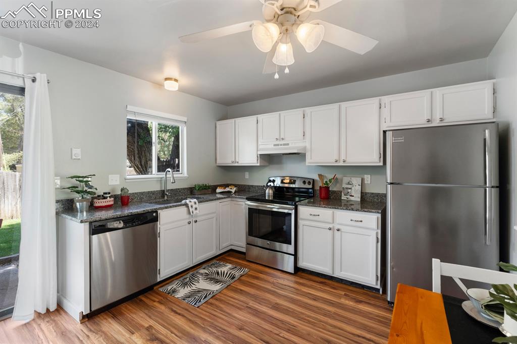 757 Alexander Road, Unit C Colorado Springs, CO 80909 - Photo 8 of 29 Kitchen with a healthy amount of sunlight, wood-type flooring, appliances with stainless steel finishes, and sink