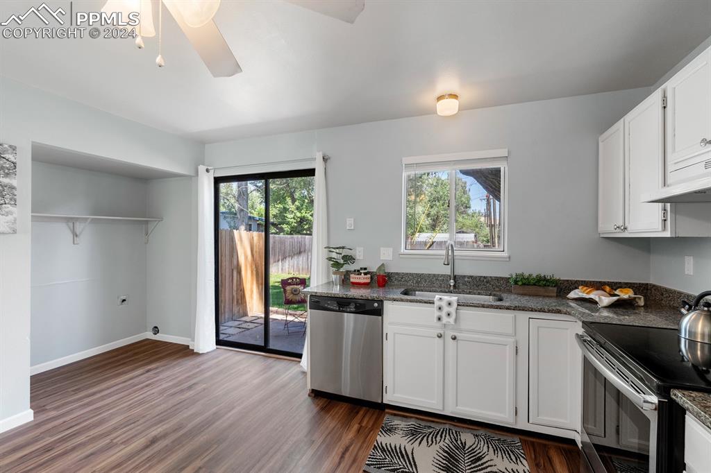 757 Alexander Road, Unit C Colorado Springs, CO 80909 - Photo 10 of 29 Kitchen featuring stainless steel appliances, white cabinets, dark hardwood / wood-style flooring, and a healthy amount of sunlight