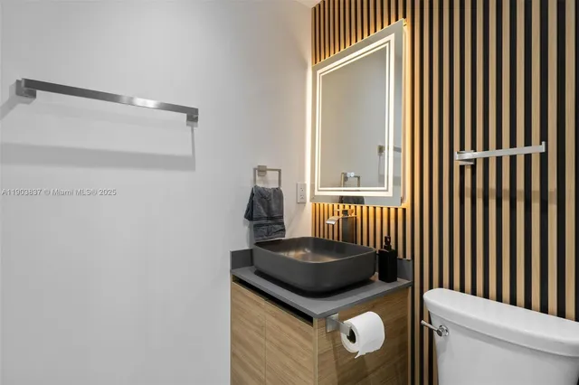 a bathroom with a granite countertop sink a toilet and a shower curtain