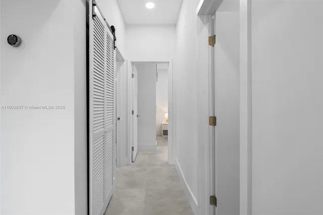 a view of a hallway with a door and closet