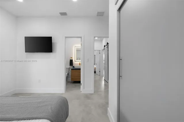 a bedroom with a bed and a flat screen tv