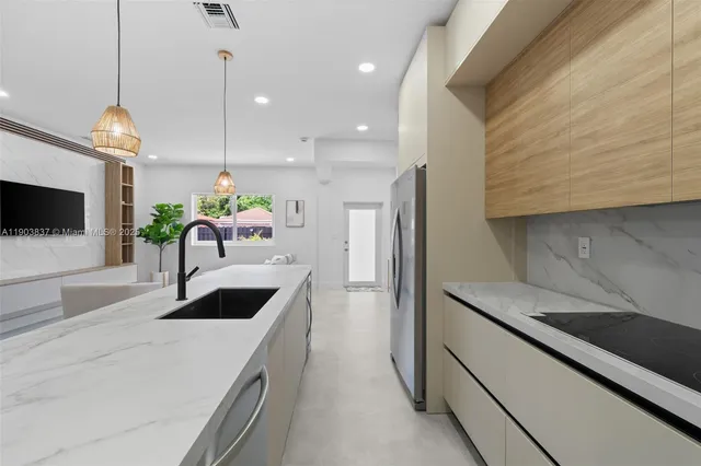 a kitchen with stainless steel appliances kitchen island granite countertop a sink a stove and a microwave
