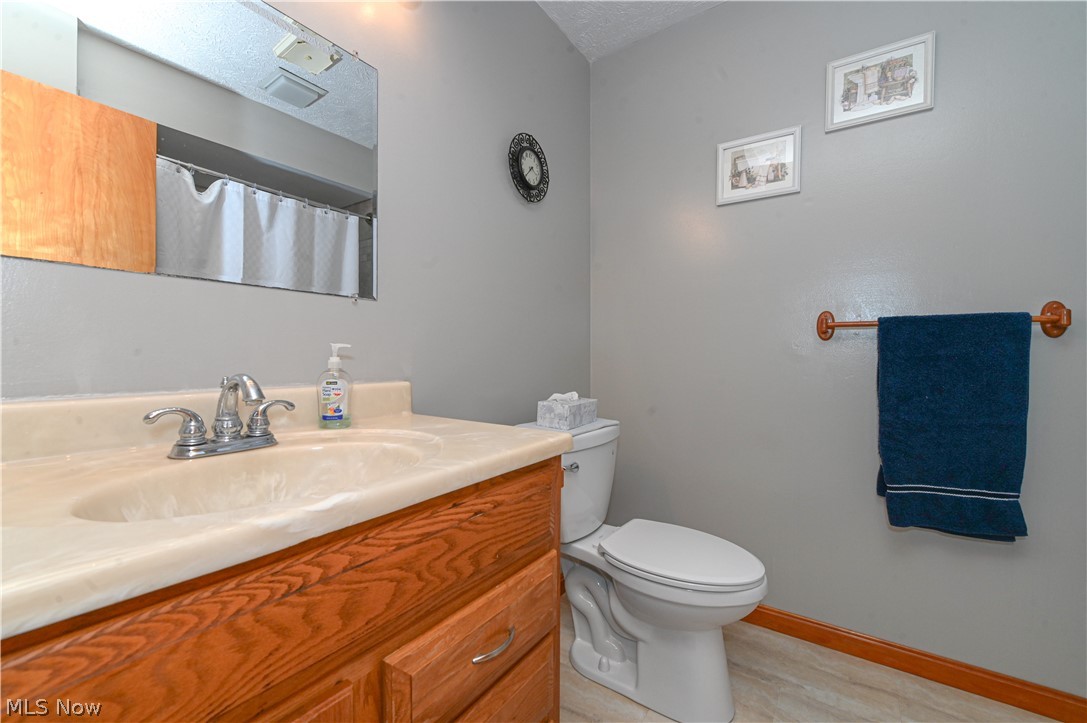 13425 Chardon-Windsor Road Chardon, OH 44024 - Photo 24 of 50 Bathroom featuring toilet, vanity, and a textured ceiling