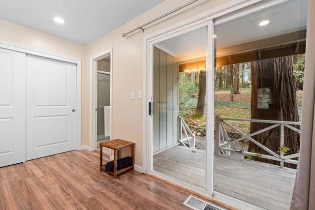 a living room with a floor to ceiling window and wooden floor