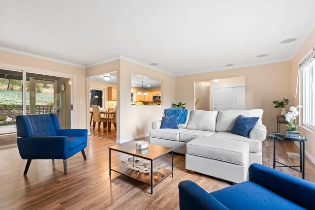 a living room with furniture wooden floor and a large window