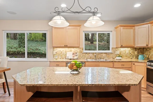 a kitchen with granite countertop sink and window