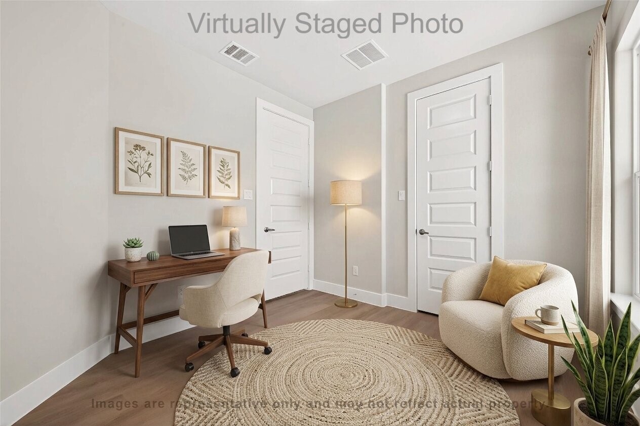 10719 Mason Road, Unit 13 Richmond, TX 77406 - Photo 14 of 50 Virtual Staging - Brightly lit home office featuring a wooden desk, a round jute rug, and a comfortable sitting area