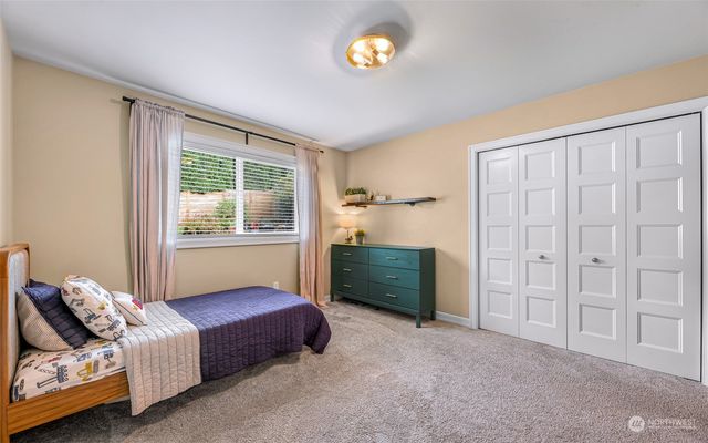 a bedroom with a bed and a flat tv screen on the dresser