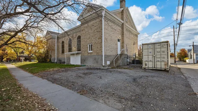 a view of a grey house with a yard