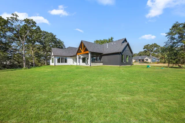 a front view of a house with a yard and trees