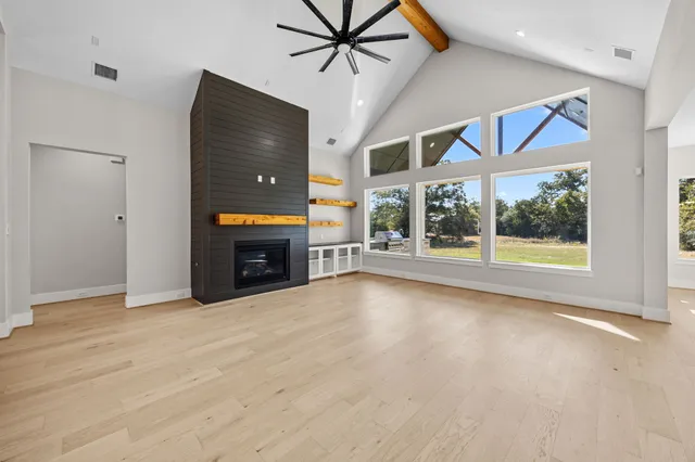 a view of an empty room with a fireplace and a window
