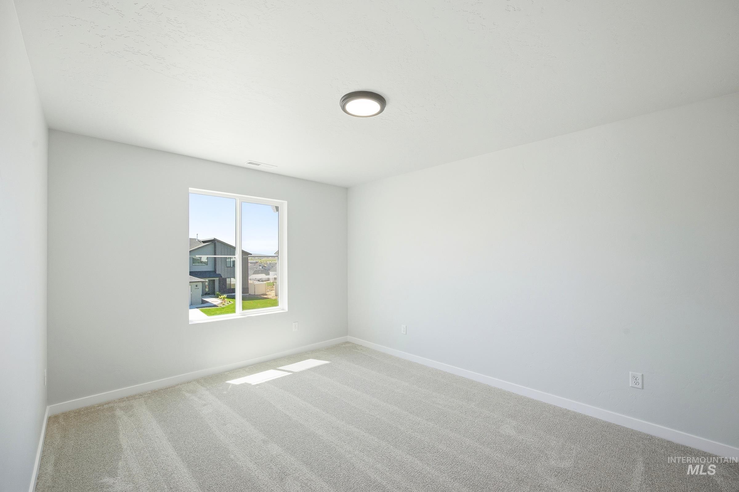 12841 Decatur Street Nampa, ID 83651 - Photo 16 of 30 Bright room featuring light gray carpet, white walls, a single window, and a flush-mount ceiling light fixture