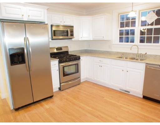 42 South Hampton Road Amesbury, MA 01913 - Photo 3 of 14 a kitchen with stainless steel appliances granite countertop a refrigerator a stove and a sink with wooden cabinets