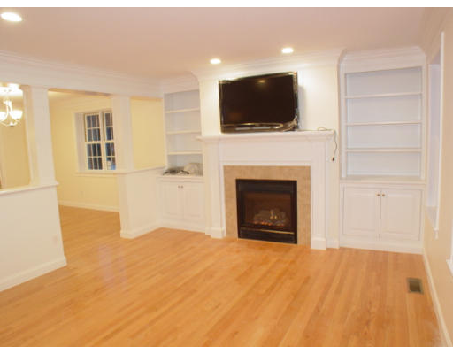 42 South Hampton Road Amesbury, MA 01913 - Photo 6 of 14 a view of a livingroom with a fireplace a flat screen tv and kitchen view